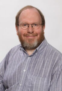A studio portrait of researcher Thomas Gill.