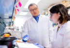 Dr. Biao He in the lab collaborating with another member of his vaccine research team.