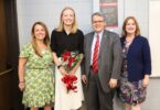 UGA President Jere W. Morehead and Morehead Honors College Dean Meg Amstutz stand with senior Sadie Bengs, holding a bouquet of red roses, and Maryann Gallagher, director of the Richard B. Russell Security Leadership Program, after surprising Bengs in class with the announcement that she is a 2025 Truman Scholar.